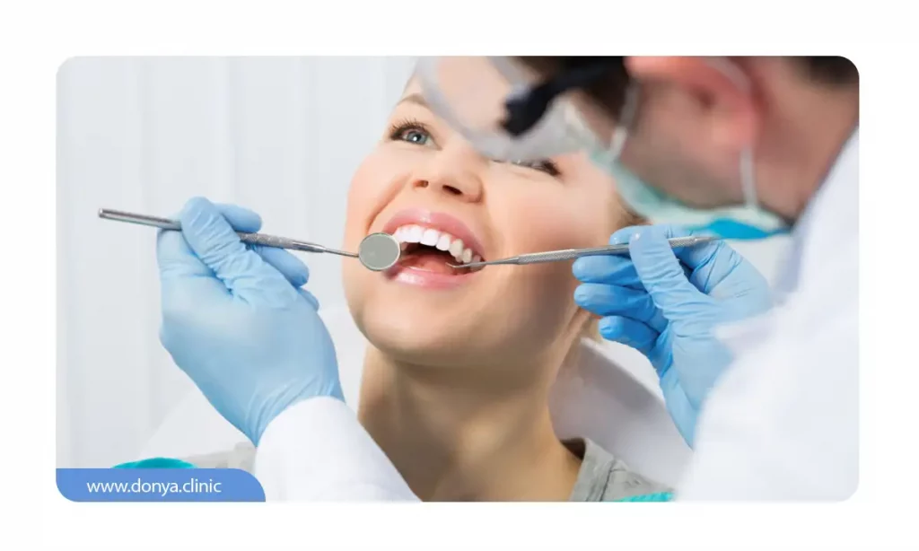 یک دندانپزشک در حال معاینه و ویزیت مراجع خودش. هزینه ویزیت از 50 هزارتومان  شروع می شود