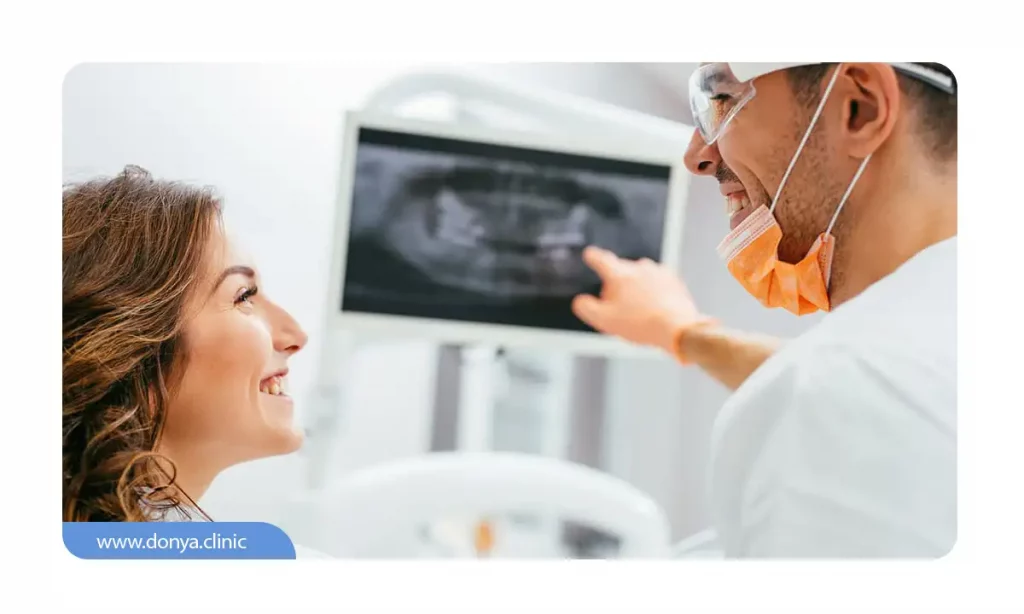 یک دندانپزشک که در حال توضیح به بیمار خود در خصوص کشیدن دندان برای ارتودنسی است