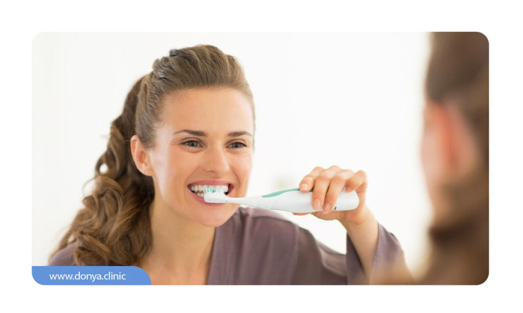 عکسی از مسواک زدن یک خانم با دندان های لمینت شده